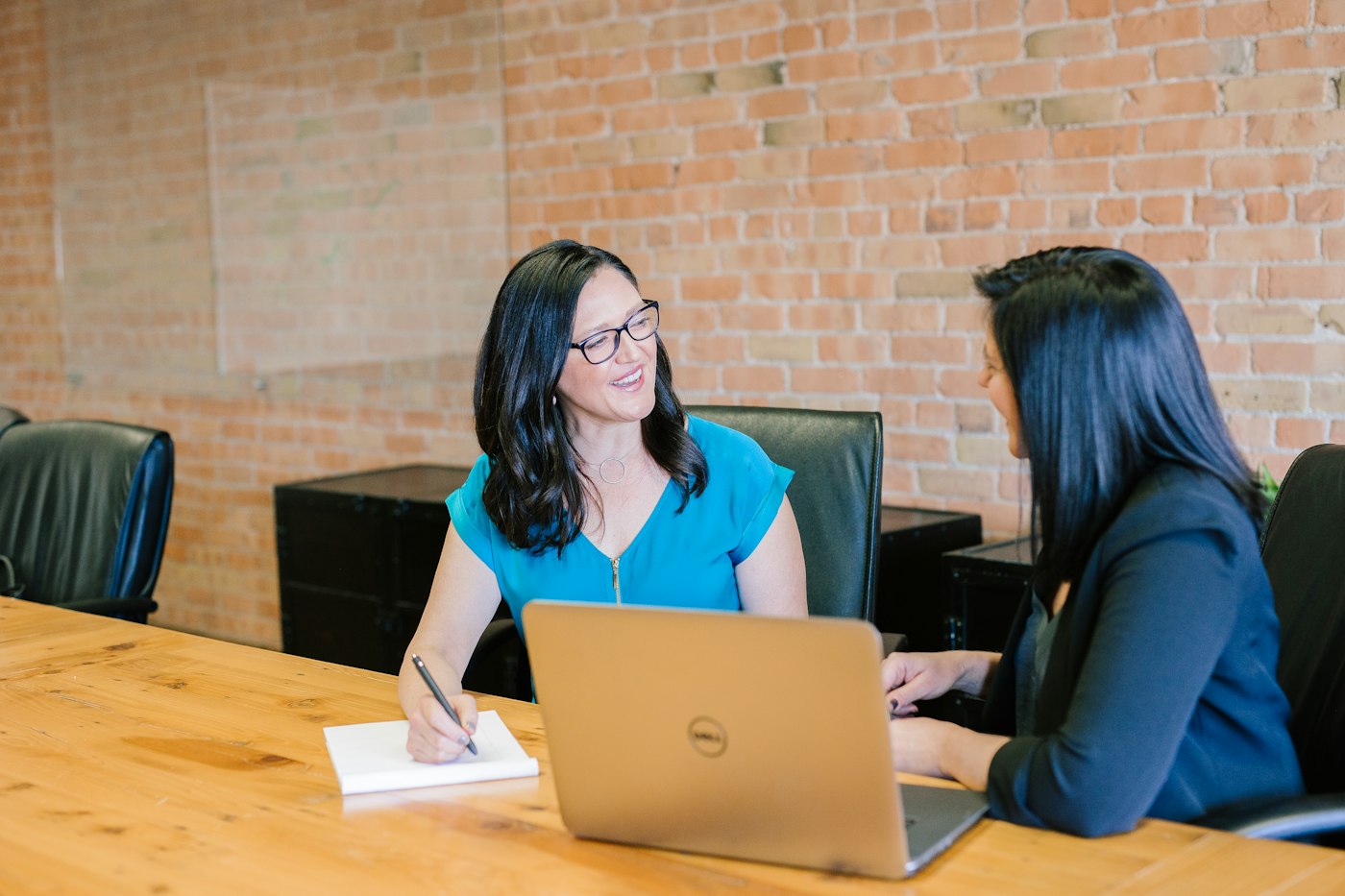 Two colleagues in discussion across a meeting table